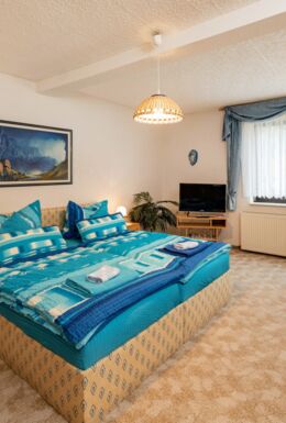 Innenaufnahme Zimmer mit Doppelbett und Sesseln