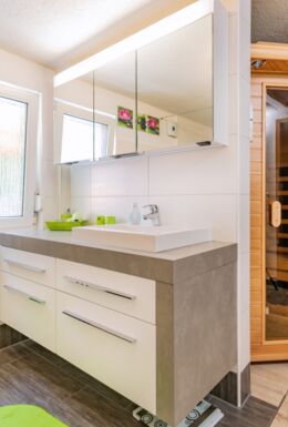 Innenaufnahme Zimmer mit Waschbecken, Spiegel und Sauna