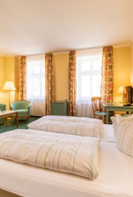 Innenaufnahme Zimmer mit Doppelbett und Sitzbereich