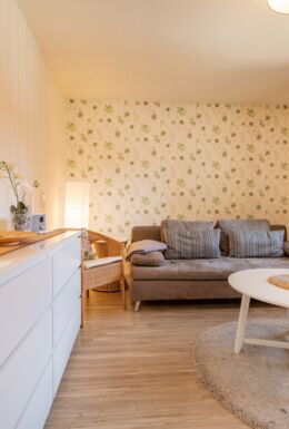 Innenaufnahme Zimmer mit Sofa, Sessel und Kommode